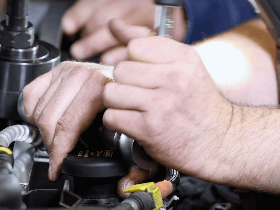Hände arbeiten am Motor